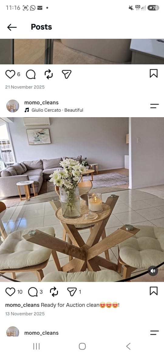 A MOMO Cleans living and dining space, with a glass dining table and fresh flowers